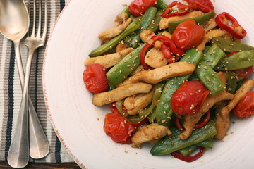 Stewed chicken breast with green bell pepper, young peas and tom