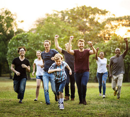 Group of people walking and running playful in the park - obrazy, fototapety, plakaty