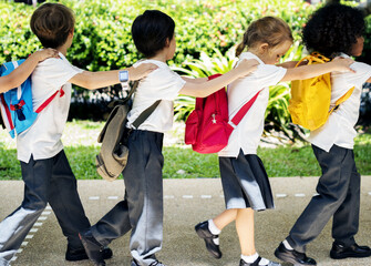 Group of diverse kindergarten students walking together - obrazy, fototapety, plakaty
