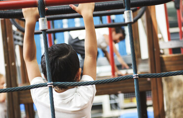 Rear view of young kindergarten boy at playground