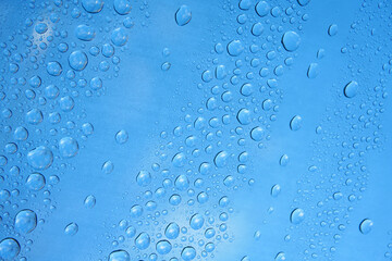 raindrop on window glass against blue sky