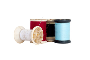 Old spool of thread with needle closeup on white background