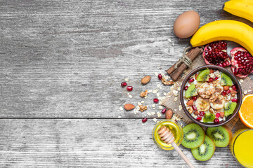 oatmeal porridge with banana, kiwi fruit, pomegranate, cinnamon and nuts
