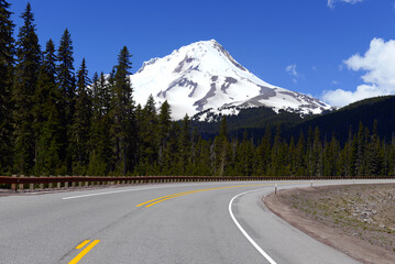 Naklejka premium Snow covered Mount Hood, a volcano in the Cascade Mountains in Oregon popular for hiking, climbing, snowboarding and skiing, despite the risks of avalanche, crevasses and volatile weather on the peak.