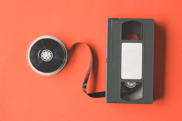 Video cassette tape and reel on orange background.