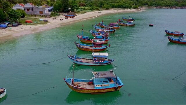 Drone Flies Slowly over Moored Fishing Boats Line by Beach