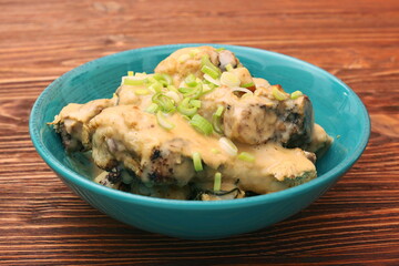 Chicken drumsticks in a bowl under creamy sauce