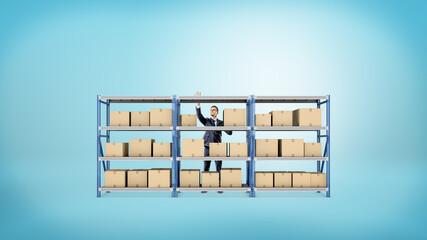 A businessman standing behind a metal warehouse rack full of boxes on blue background.