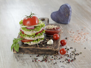 Vegetarian sandwich with vegetables on a wooden board. 