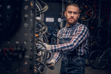 Obraz na płótnie Canvas Mechanic doing bicycle wheel service manual in a workshop.