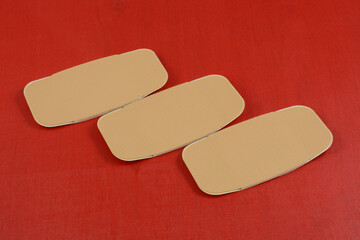Three large first aid adhesive bandages on red background