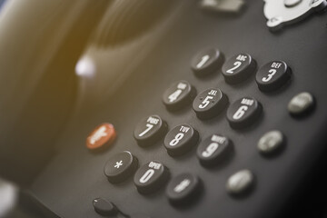 A close up of a Black office IP Phone on a desk 
