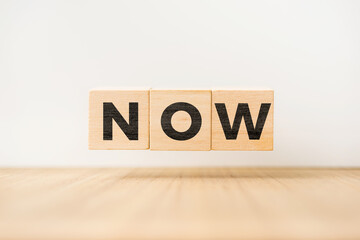 Surreal abstract geometric floating wooden cube with vocabulary "NOW" concept on wood floor and white background