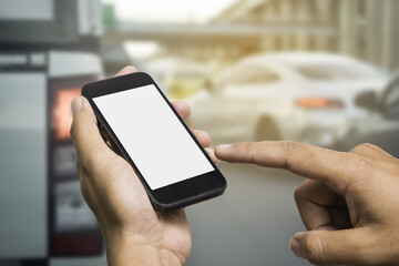 Hand of a man holding a smartphone and touching the screen, traffic jam