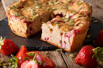Fruit banana bread with strawberries and pumpkin seeds close-up on a table. Horizontal