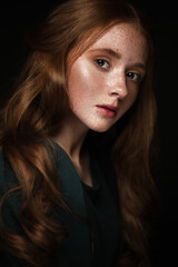 Beautiful Redhead girl with a perfectly curls hair and classic make-up. Beauty face. Picture taken in the studio.
