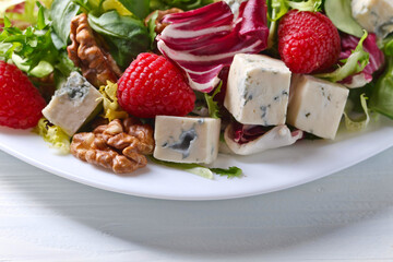 Green salad with blue cheese , raspberry and nuts