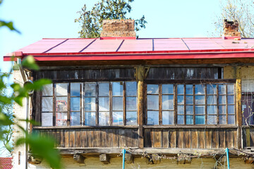 Ancient wooden balcony of an old mansion with a red roof