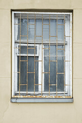 abandoned cracked stucco wall with window grilles