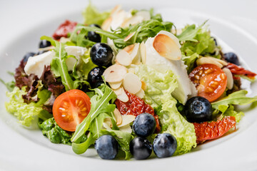 Vegetarian spring salad with greens, nuts and blueberries