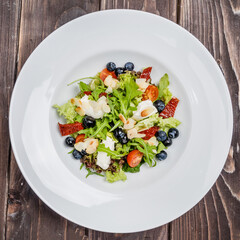 Vegetarian spring salad with greens, nuts and blueberries