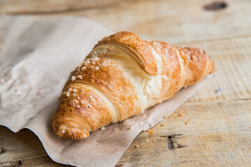 Fresh croissant lies on paper