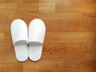 White slipper on wooden floor.