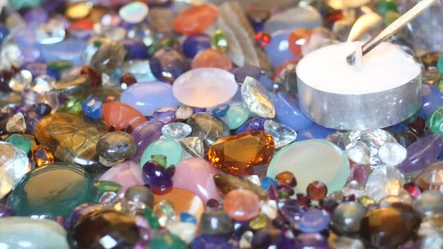 candle fire set up on precious sparkling gemstones surface