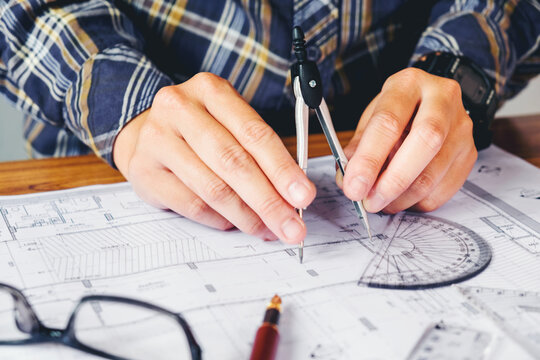 Architect or engineer working in office on blueprint. Architects workplace , blueprints, ruler, helmet and divider. Construction concept. Engineering tools