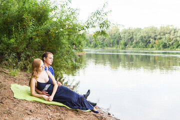 summer holidays, love, romance and people concept - happy smiling young couple hugging outdoors