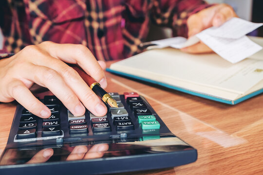 Businessman's hands with calculator and cost at the office and Financial data analyzing counting on wood desk
