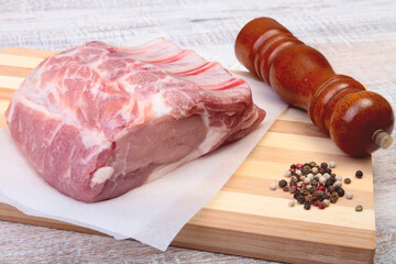 Raw pork chops and spice grinder on cutting board. Ready for cooking.