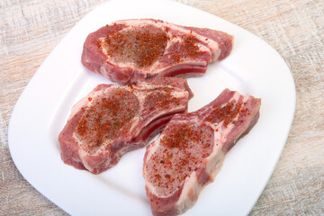 Raw pork chops, spices on cutting board. Ready for cooking.