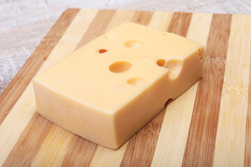 Italian piece of cheese on a wooden cutting board