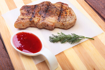 grilled pork chop with Cranberry sauce on plate on wooden board