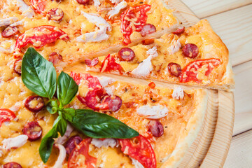 Pizza with salami on the wooden background