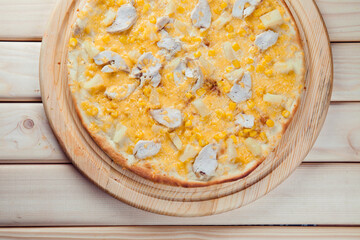 Pizza with pineapple on the wooden background