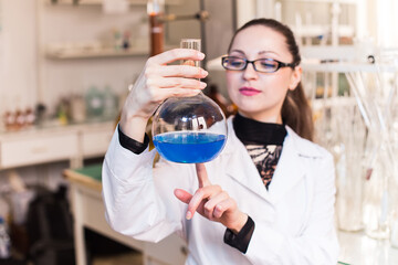 Beaker with liquid in the hands of women scientific