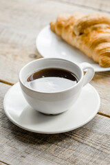 Office lunch with coffee and croissant on wooden table background