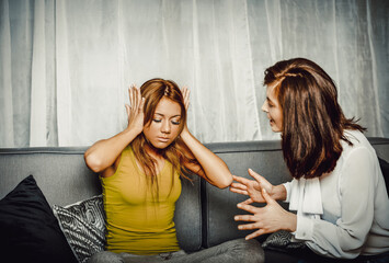 Mother and doughter sitting on sofa.