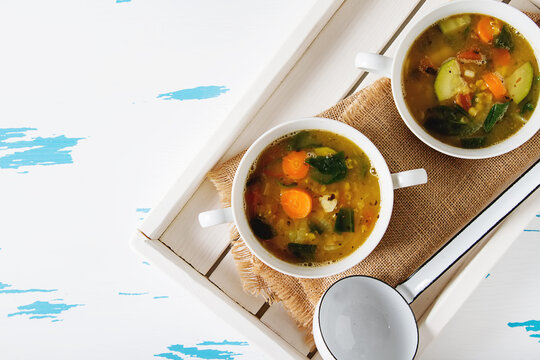 Winter detox soup of lentils in a ceramic bowl on a wooden background. Clean eating, weight loss, vegetarian food concept. Copy space. Top view