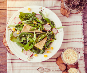 Green salad with baby spinach, corn, radish, sesame.Toning.