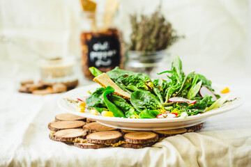 Full bowl of fresh salad with baby spinach, corn and crispy crackers