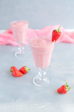 Fresh and Cold Strawberry Smoothie in Tall Glasses on Grey Background 