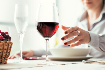 Woman tasting wine and having lunch