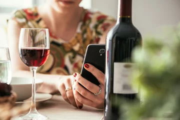 Crédence de cuisine en verre imprimé Bar Woman using a wine app at the restaurant