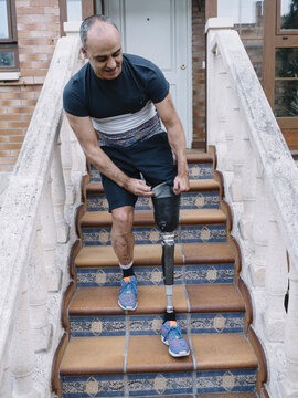 Disable man wearing a prosthesis leg on steps