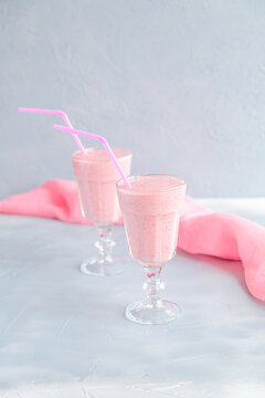Fresh and Cold Strawberry Smoothie in Tall Glasses on Grey Background 