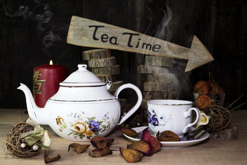Cup of Tea and Teapot On Wooden Table. Arrow Sign With Text, Tea Time Written On It in The...