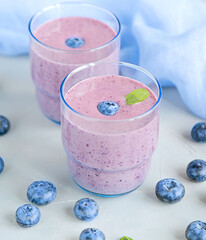 Fresh Cold Blueberry Smoothie in Glass Decorated with Blue Fabric